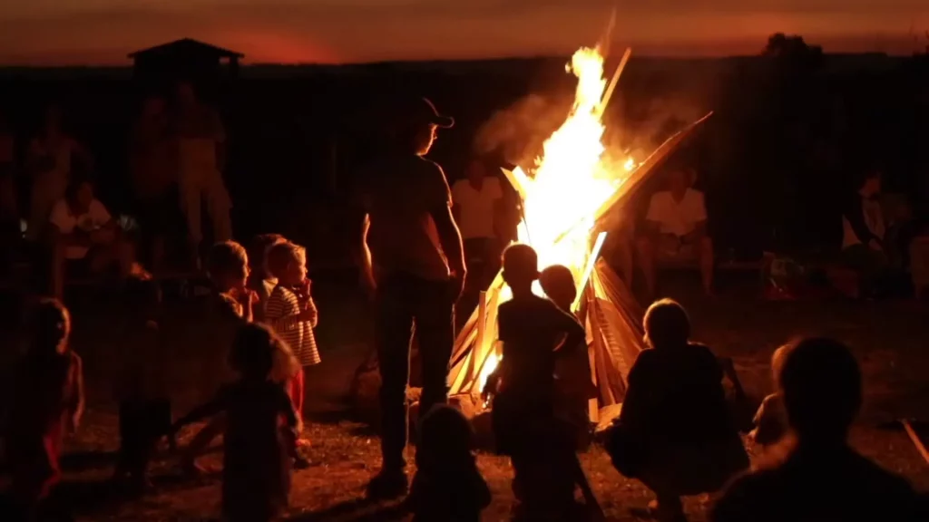 Auswandern Paraguay Erfahrungen: Jan steht am Lagerfeuer beim Ypi See umgeben von vielen Kindern